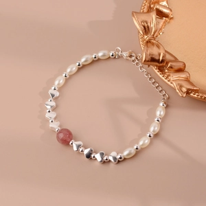 Macro shot of freshwater pearl bracelet with heart beads and strawberry quartz detail