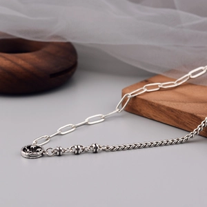 Retro silver necklace featuring asymmetric chains and a vintage hollow circular pendant