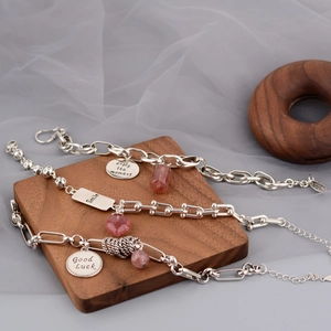 Detailed view of S925 silver bracelets with strawberry quartz and engraved charms