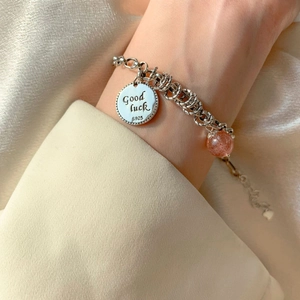 Detail of S925 silver bracelet with Good Luck tag and red strawberry quartz bead