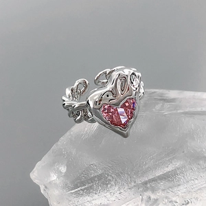Detailed macro view of heart-shaped pink gemstone set on vintage silver chain ring band