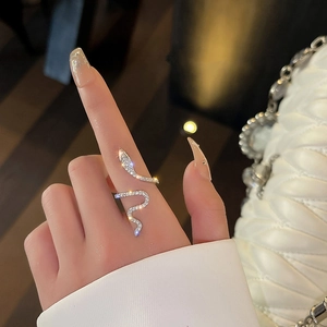 Anillo de serpiente plateado con circonitas brillantes en la mano de modelo