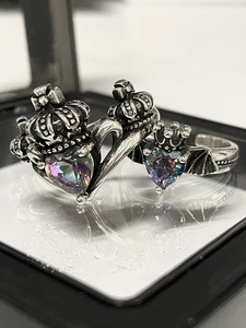 Macro shot of vintage silver rings featuring crown and bat wings with heart aurora stones