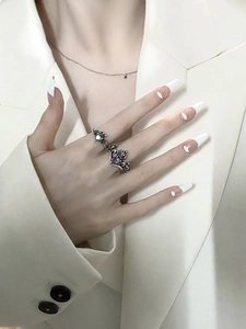 Close-up of vintage silver crown and bat wing rings with purple heart gemstones