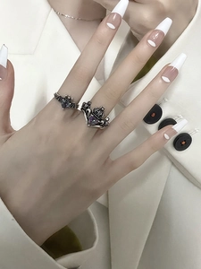 Macro shot of gothic rings featuring purple heart zircon in bat and crown designs
