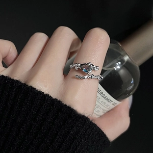 Close-up of adjustable lava texture silver ring featuring a dark iridescent gemstone