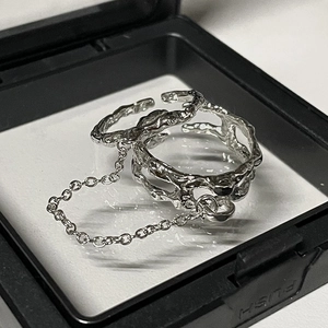 Unregelmäßiger silberner Kettenring mit flüssiger Metalltextur in einer Geschenkbox