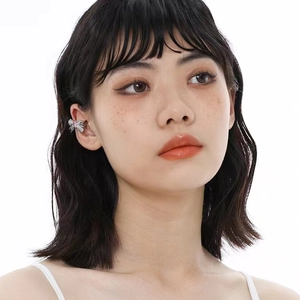 Elegant silver butterfly ear cuff with pink cubic zirconia on a female model