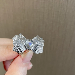 Niche silver bow ring with heart moonstone and irregular texture in minimalist style