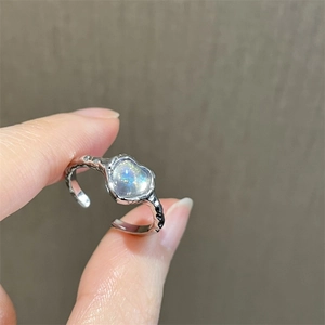 Minimalist silver lava style open ring with heart-shaped moonstone held by hand