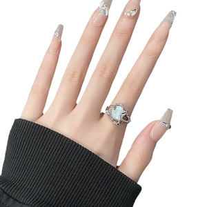 Irregular liquid metal silver ring with oval moonstone on model hand with silver nails