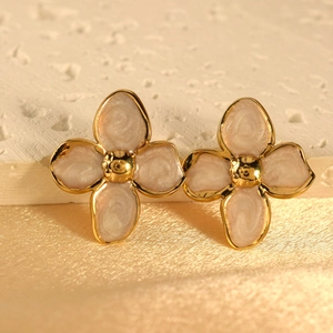 Macro detail of vintage floral earrings with pink enamel petals and gold metal core