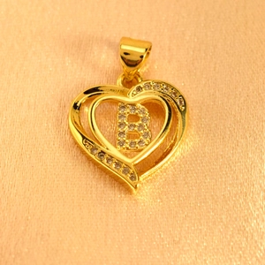 Macro shot of gold heart pendant with letter B pave diamonds and S925 hallmark