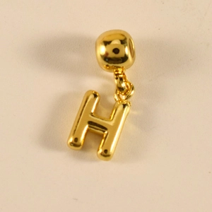 Nahaufnahme des goldenen Buchstaben-H-Anhängers mit polierter Oberfläche an der Kette