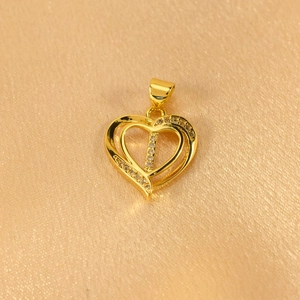 Macro detail of gold-plated heart pendant with crystal-encrusted letter I