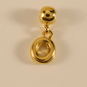 Makro-Detail des polierten goldfarbenen Buchstabens O Anhänger mit glattem Finish