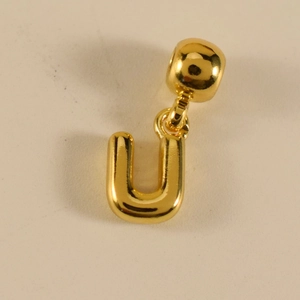 Nahaufnahme des goldenen Buchstaben-U-Anhängers mit polierter Oberfläche und Öse