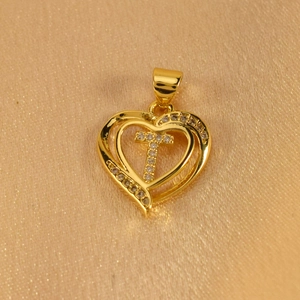 Close-up of golden double heart pendant with cross and white zircon pavé setting