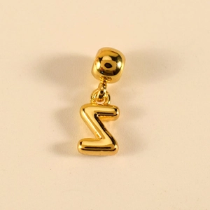 Nahaufnahme eines polierten goldenen Buchstaben Z Anhängers mit glattem Metallic-Finish