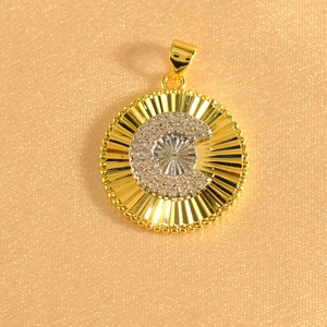 Macro shot of gold-plated sunburst pendant featuring crystal-encrusted letter C