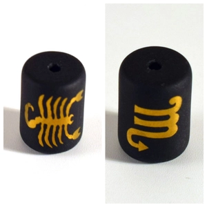 Detail of matte black cylinder beads featuring yellow Scorpio sign and scorpion patterns