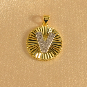 Detailed view of gold plated round sunburst pendant with crystal inlaid letter V