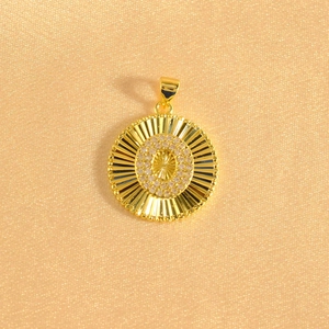 Detail of gold-plated sunburst pendant with zircon stones and center star engraving