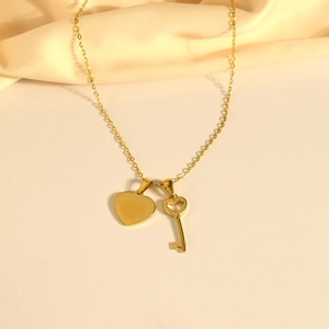 Gold stainless steel necklace featuring minimalist heart and key pendants on fine chain