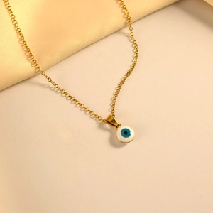 Collar minimalista de oro con colgante de ojo turco en esmalte blanco sobre fondo de satén