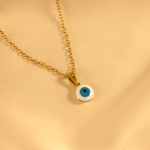 Elegante collar de acero inoxidable dorado con colgante de ojo turco sobre satén champán