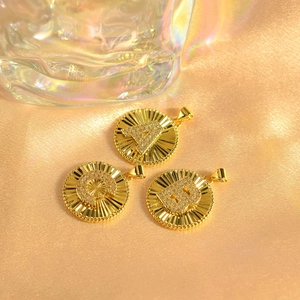 Gold plated sunburst alphabet pendants with sparkling pavé crystals and radial texture