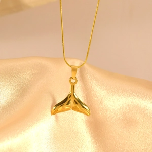 Polierte goldene Walflossen-Halskette präsentiert auf elegantem goldenem Seidenhintergrund