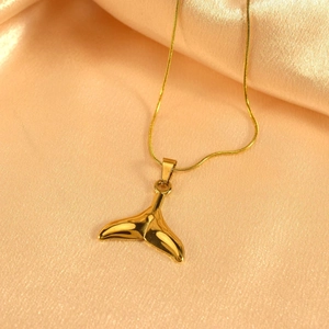 Elegante Halskette mit goldenem Walflossenhänger auf Champagner-Satin mit Schlangenkette