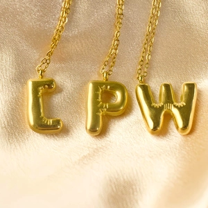 Minimalistische 3D-Ballon-Buchstabenketten L P W in Gold auf elegantem Seidenhintergrund