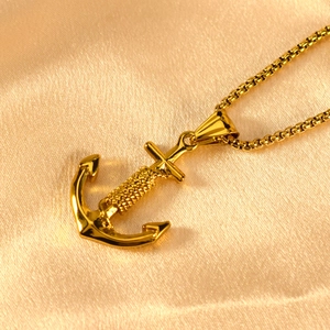 Detail of a golden anchor pendant with rope texture on a delicate box chain