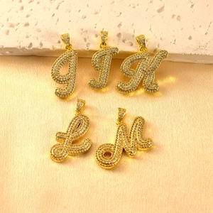 Nahaufnahme der trendigen Buchstaben Zirkonia Anhänger mit funkelnden Steinen für Schmuck.