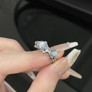 Lava liquid silver ring with iridescent moonstone inlays shown on hand display