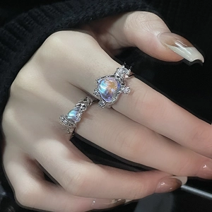 Detailed view of gothic silver moonstone heart ring set with iridescent stones on hand