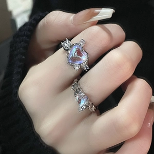Detailed view of heart moonstone ring and liquid metal ring on model fingers