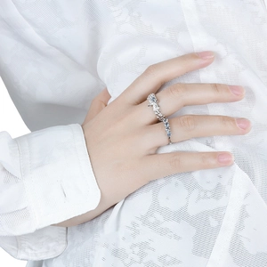 Bague en argent texture lave avec zircons bleus sur fond de tissu blanc texturé