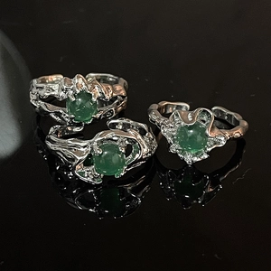 Vista detallada de anillos de plata con textura de lava y piedras de jade verde
