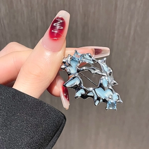 Artistic silver textured brooch with light blue resin inlay and square gemstones