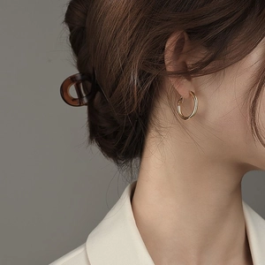 Minimalistische goldene Creolen im französischen Stil und Schildpatt Haarklammer an Modell