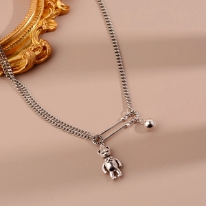 Détail du pendentif ours argenté sur chaîne à maillons fer à cheval et trombone