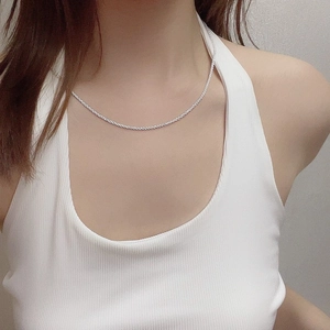 Minimalist silver chain necklace on female model wearing white ribbed top in close-up shot