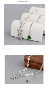 Détail du pendentif ours mécanique articulé avec gemme verte sur collier en argent