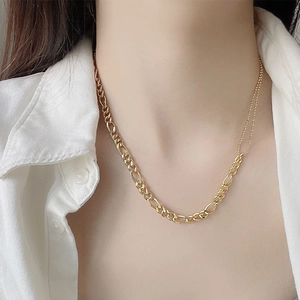 Detailansicht des gemischten Goldkettendesigns mit Figaro- und Perlenkette am Hals