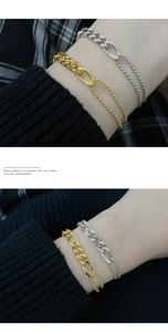 Detailansicht des Gold und Silber Spleißkette Armbands am Handgelenk mit Strickärmel