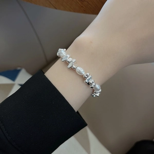 Nahaufnahme des Perlenarmbands mit weißen ovalen Perlen und silbernen Metallelementen