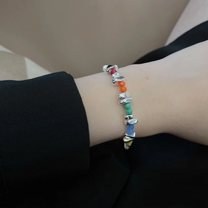 Detailaufnahme des Regenbogen-Perlenarmbands mit silbernen Metallelementen am Handgelenk